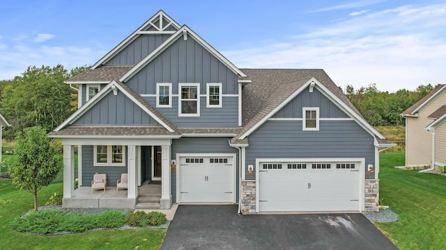 craftsman house with a garage, a front yard, and covered porch