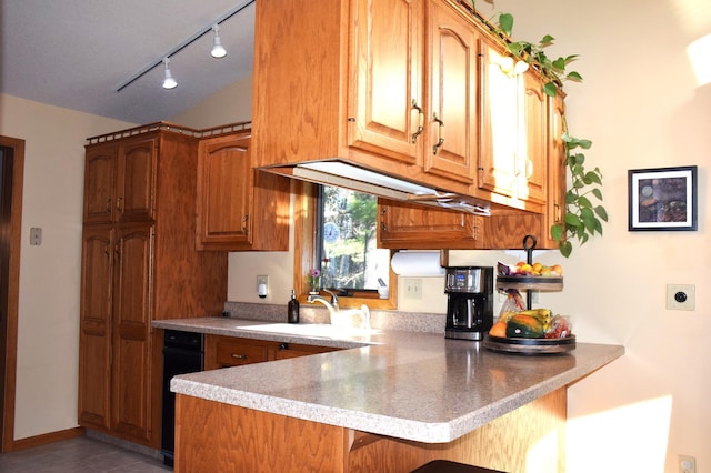 2935 Acorn Ln NE, Bemidji, MN 56601 - kitchen with a sink, a peninsula, a breakfast bar area, track lighting, and brown cabinetry