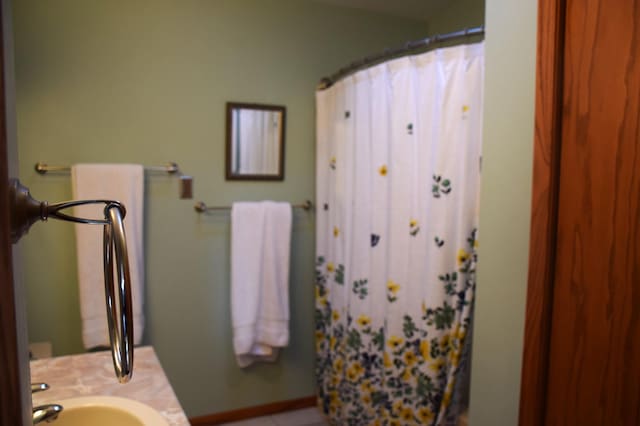 2935 Acorn Ln NE, Bemidji, MN 56601 - full bath featuring vanity, a shower with shower curtain, and baseboards