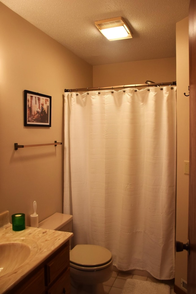 2935 Acorn Ln NE, Bemidji, MN 56601 - full bathroom with vanity, toilet, a textured ceiling, and tile patterned floors