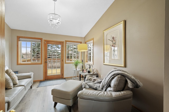 living room featuring an inviting chandelier, light wood-type flooring, and vaulted ceiling