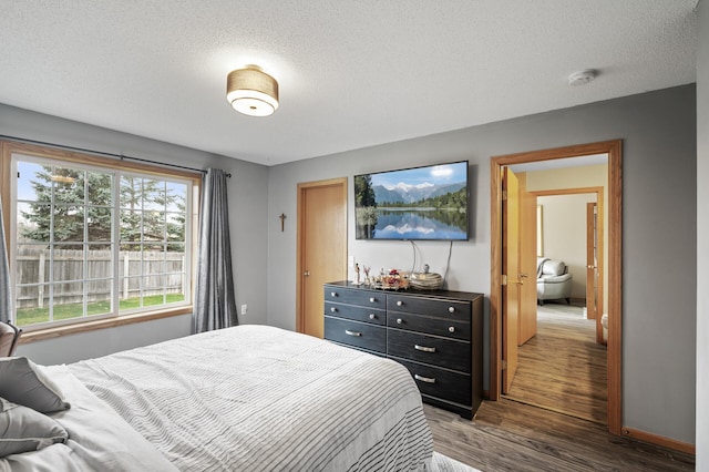 bedroom with hardwood / wood-style floors and a textured ceiling