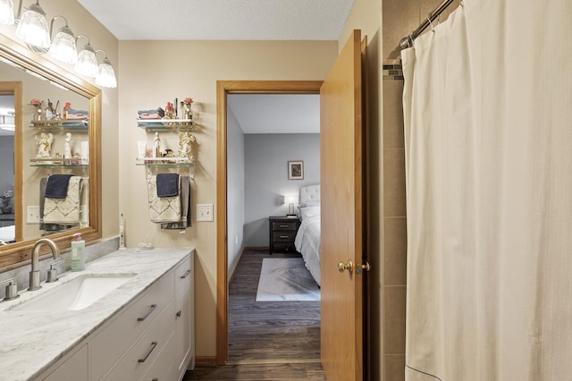 bathroom with hardwood / wood-style flooring, vanity, a shower with curtain, and a textured ceiling