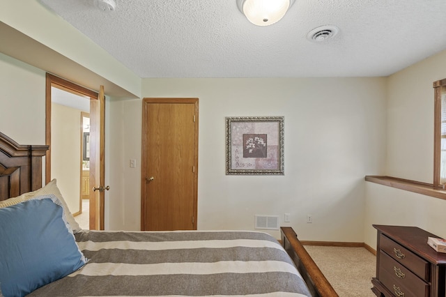 carpeted bedroom featuring a textured ceiling