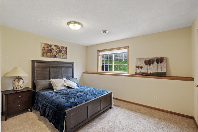 bedroom with light carpet and a textured ceiling