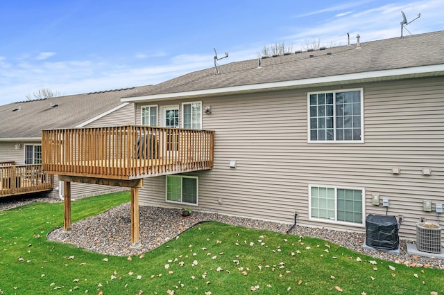 rear view of property with central AC unit, a yard, and a wooden deck