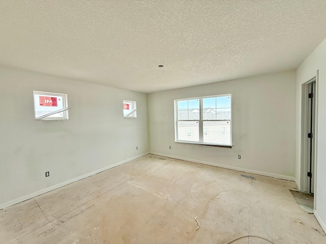 unfurnished room with a textured ceiling