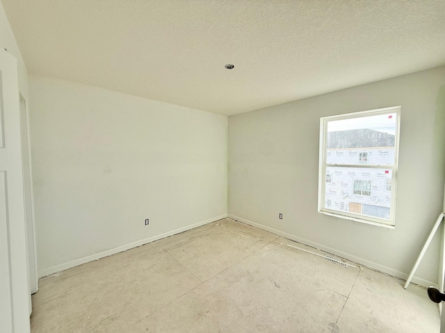 unfurnished room featuring a textured ceiling