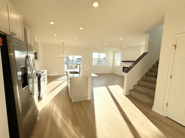 interior space featuring light wood-type flooring, an inviting chandelier, stairway, and recessed lighting