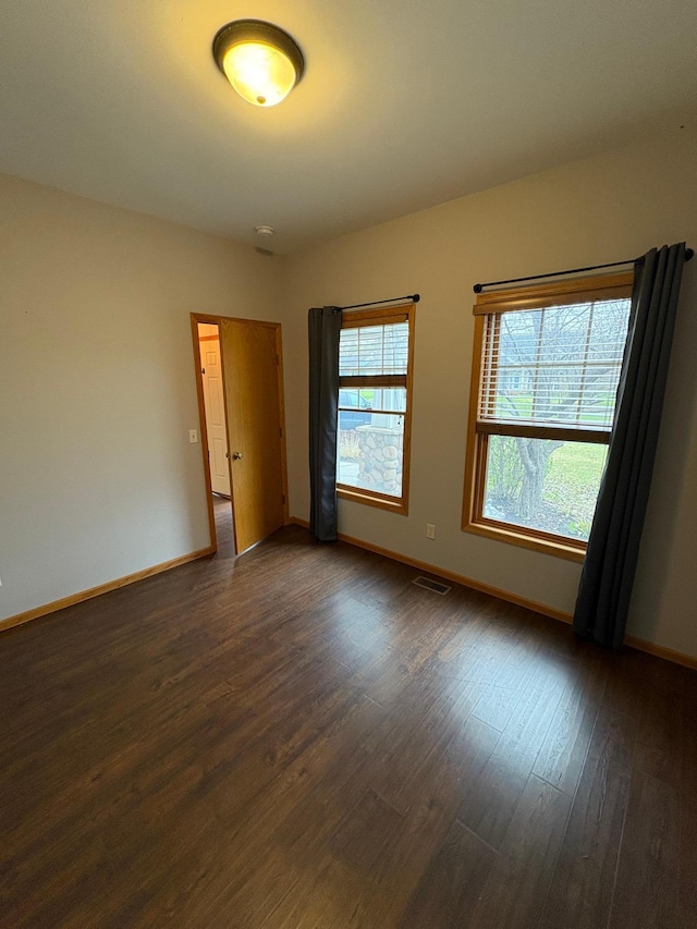 unfurnished room with dark hardwood / wood-style floors