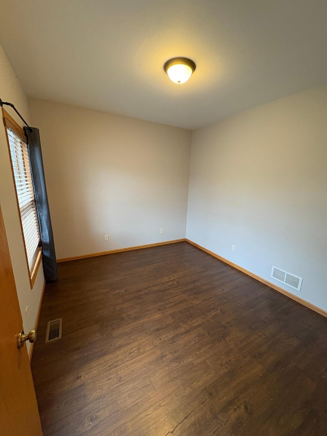 spare room featuring dark wood-type flooring