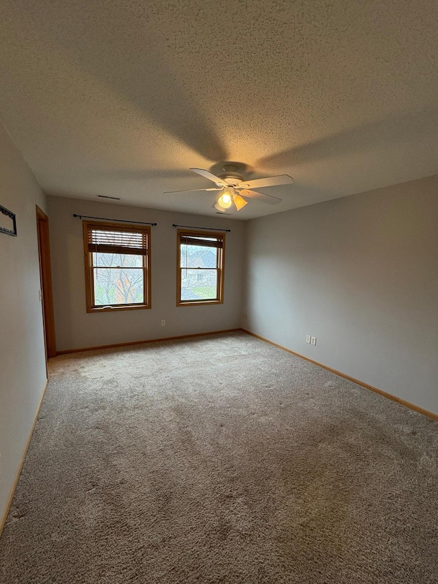 carpeted empty room featuring a textured ceiling and ceiling fan