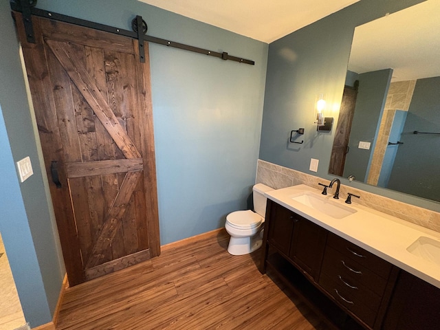 bathroom with hardwood / wood-style floors, vanity, and toilet