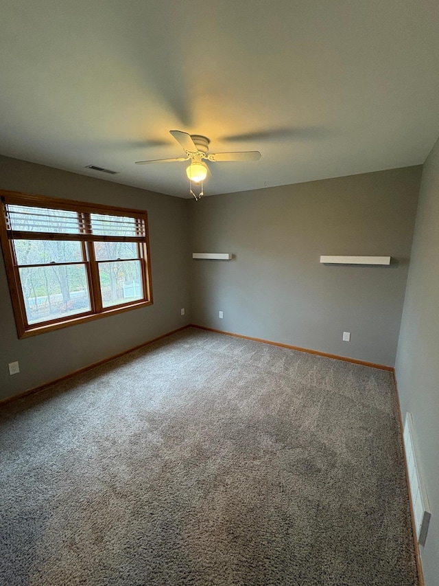 carpeted spare room featuring ceiling fan