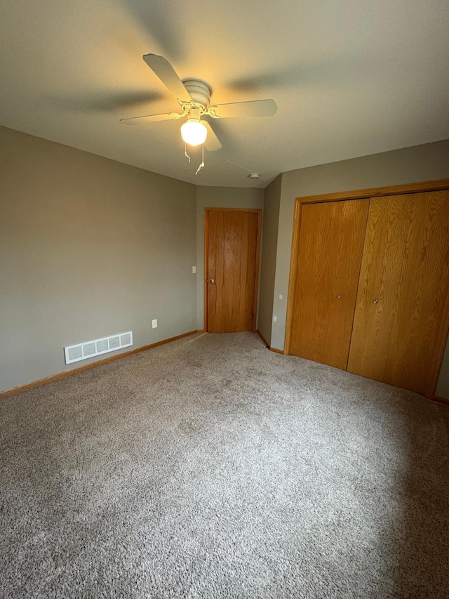 unfurnished bedroom featuring ceiling fan, a closet, and carpet