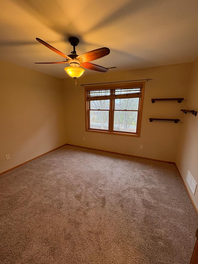 empty room with ceiling fan and carpet floors