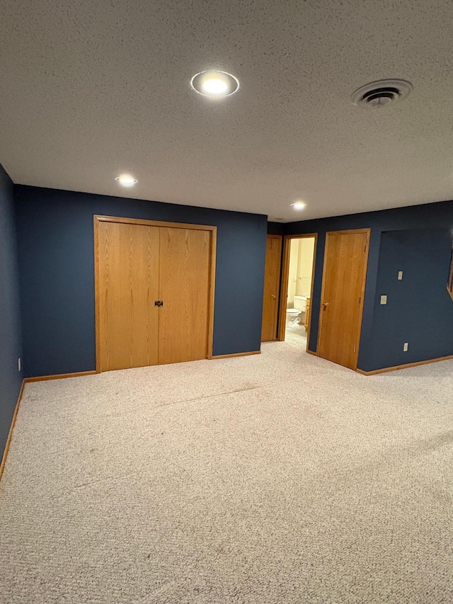 unfurnished bedroom featuring carpet floors and a textured ceiling