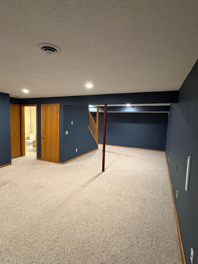 basement featuring carpet and a textured ceiling