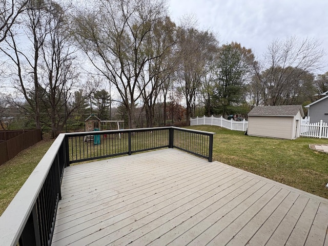 deck with a playground, a yard, and a storage shed