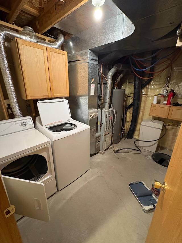 laundry area with cabinets, gas water heater, and separate washer and dryer