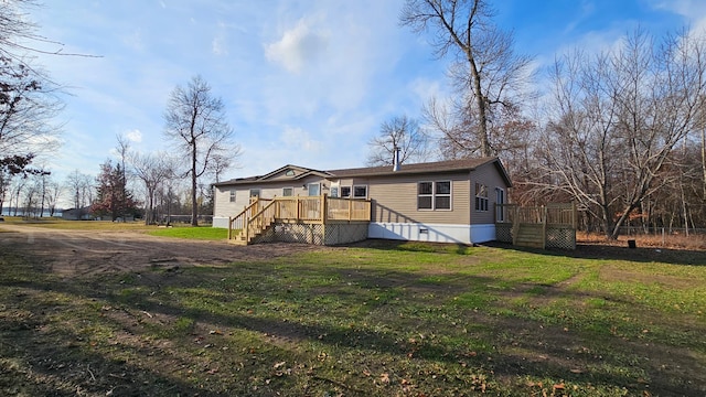 rear view of property with a deck and a yard