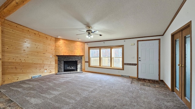 unfurnished living room with carpet, a textured ceiling, and crown molding