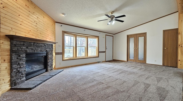 unfurnished living room featuring a textured ceiling, a stone fireplace, carpet floors, and lofted ceiling