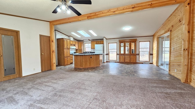 kitchen featuring white fridge, lofted ceiling with skylight, plenty of natural light, and crown molding