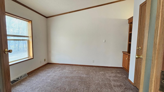 carpeted spare room with ornamental molding and a textured ceiling