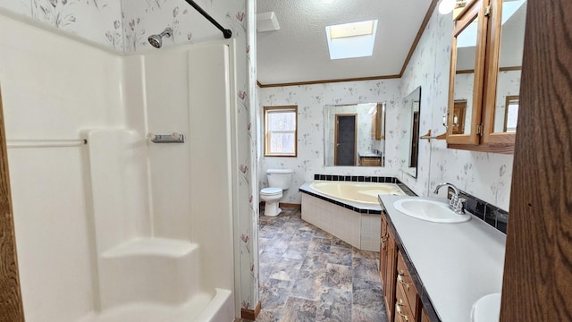 full bathroom with vanity, crown molding, a skylight, toilet, and a textured ceiling