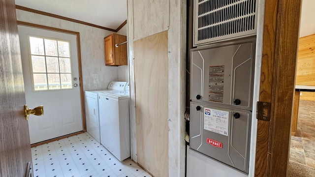 clothes washing area featuring washer and dryer, cabinets, and ornamental molding