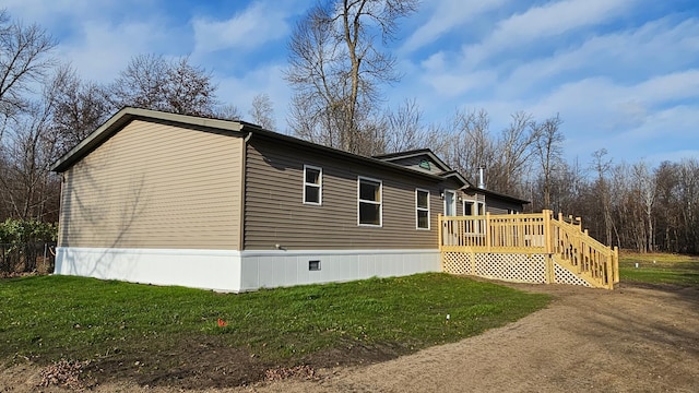 view of side of home with a lawn and a wooden deck