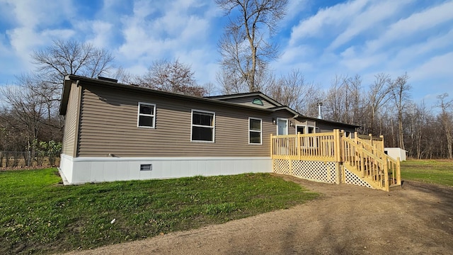 rear view of property featuring a yard and a deck