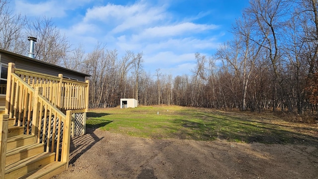 view of yard with a deck and a storage shed