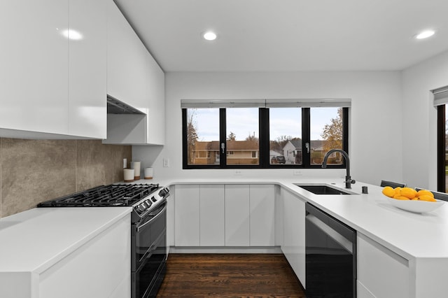 kitchen with decorative backsplash, dark hardwood / wood-style flooring, sink, black appliances, and white cabinets