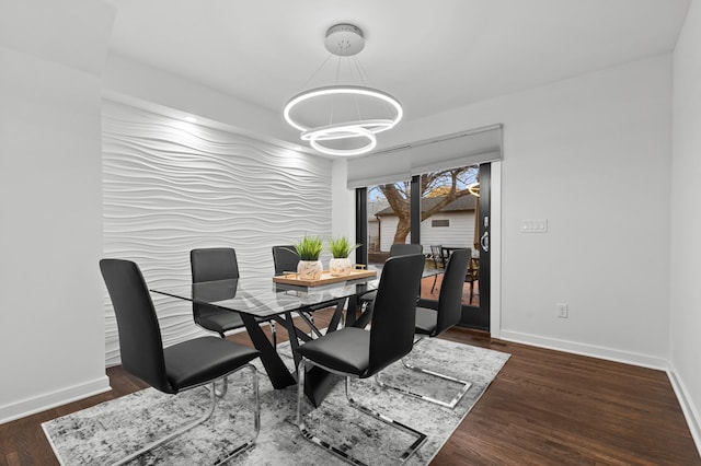 dining area featuring an inviting chandelier and dark wood-type flooring