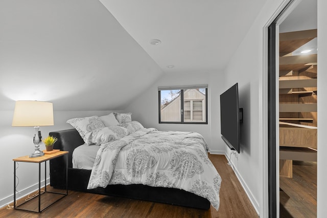 bedroom with dark hardwood / wood-style flooring and lofted ceiling