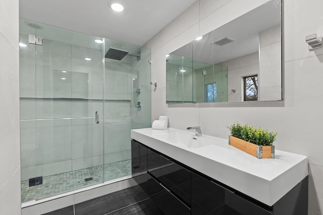 bathroom with tile patterned floors, vanity, and a shower with shower door