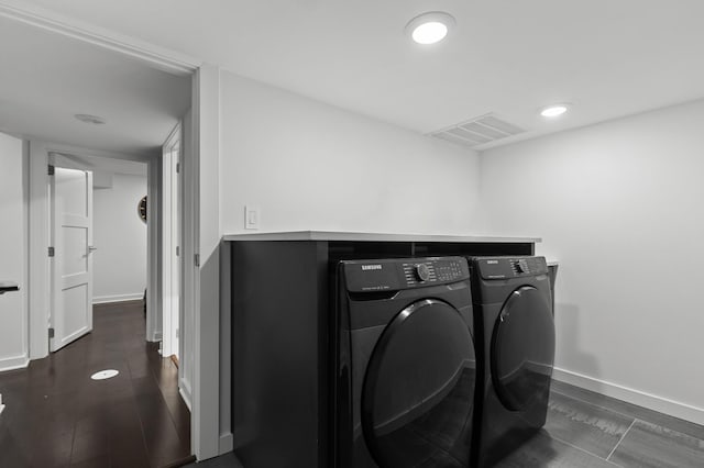 laundry area with washer and dryer and dark hardwood / wood-style floors