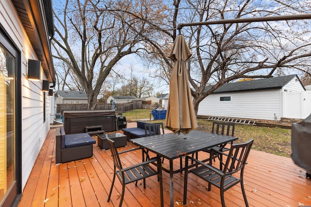 deck featuring a hot tub and a storage unit