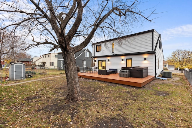 back of property featuring a yard, a storage unit, and a deck