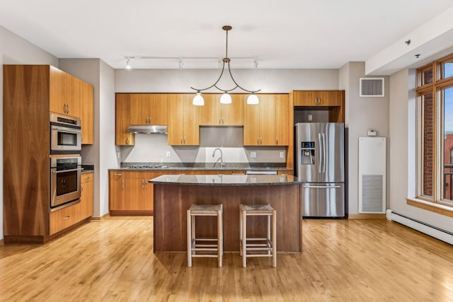 kitchen with a kitchen island, light wood-type flooring, and stainless steel appliances