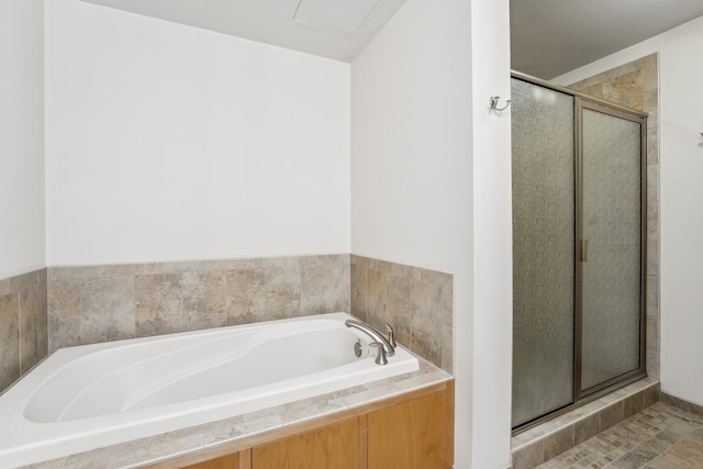 bathroom featuring a garden tub and a shower stall