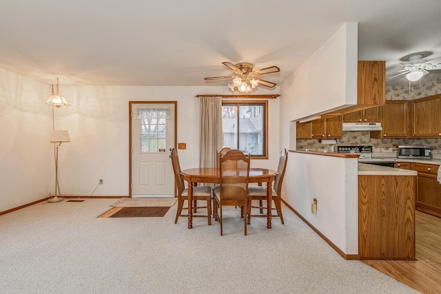 carpeted dining room featuring ceiling fan