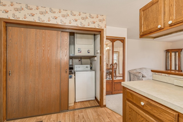 laundry room featuring stacked washing maching and dryer and light wood-type flooring