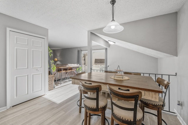 dining space featuring light hardwood / wood-style floors and a textured ceiling