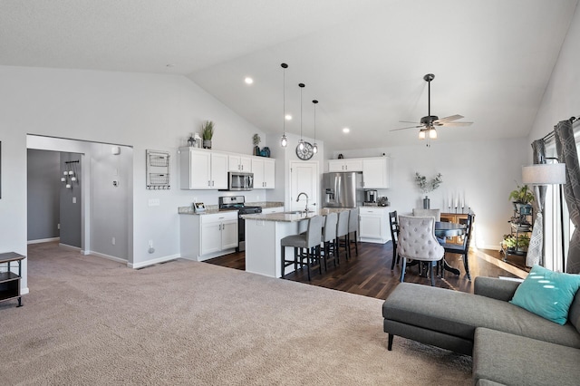 carpeted living room featuring ceiling fan, sink, and high vaulted ceiling