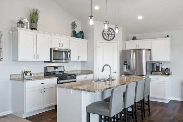 kitchen with white cabinetry, appliances with stainless steel finishes, sink, and a center island with sink