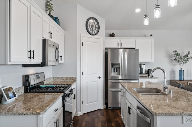 kitchen with stainless steel appliances, white cabinetry, decorative light fixtures, dark hardwood / wood-style floors, and a kitchen island with sink