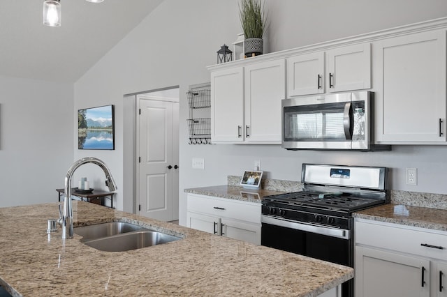 kitchen with white cabinets, lofted ceiling, an island with sink, and appliances with stainless steel finishes